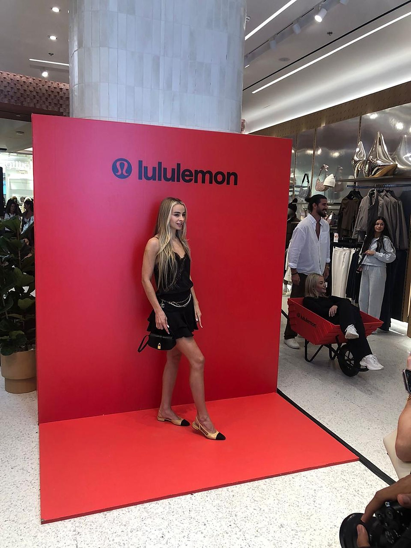 Guest posing at the red lululemon photo wall